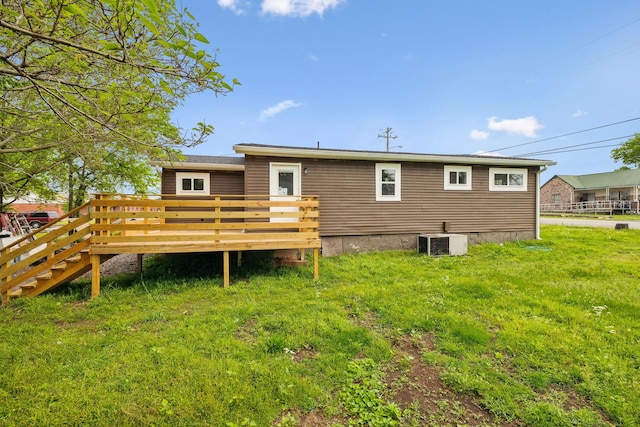 rear view of house with a deck and cooling unit