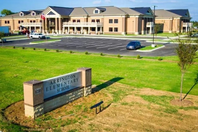 exterior space featuring a yard, uncovered parking, and a residential view