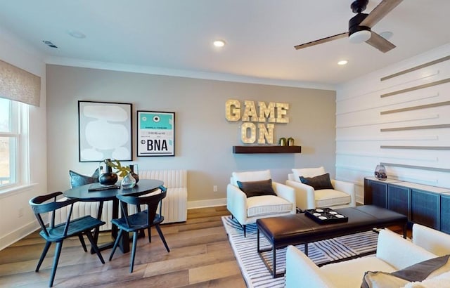living area featuring crown molding, radiator, ceiling fan, and wood finished floors