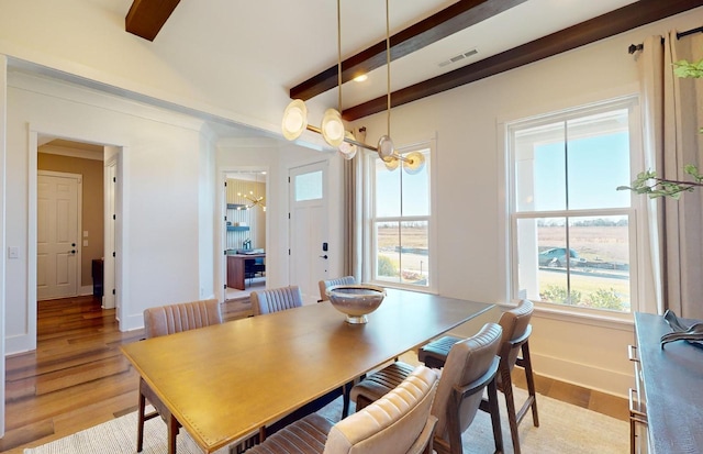 dining area with an inviting chandelier, beamed ceiling, light wood finished floors, baseboards, and visible vents