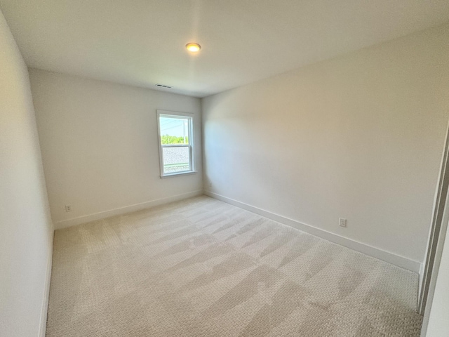 unfurnished room with visible vents, baseboards, and light carpet