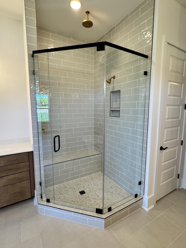 full bath with tile patterned floors, a shower stall, and vanity