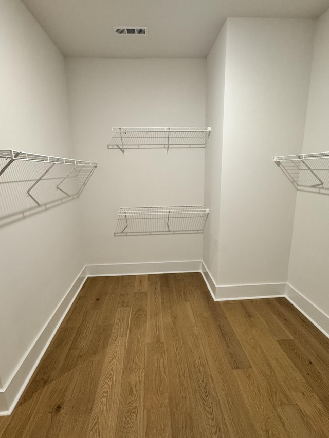 spacious closet featuring visible vents and wood finished floors
