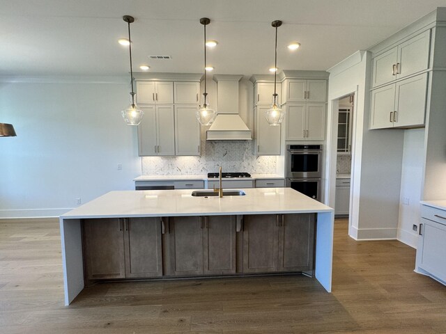 kitchen with decorative backsplash, visible vents, premium range hood, baseboards, and stainless steel double oven