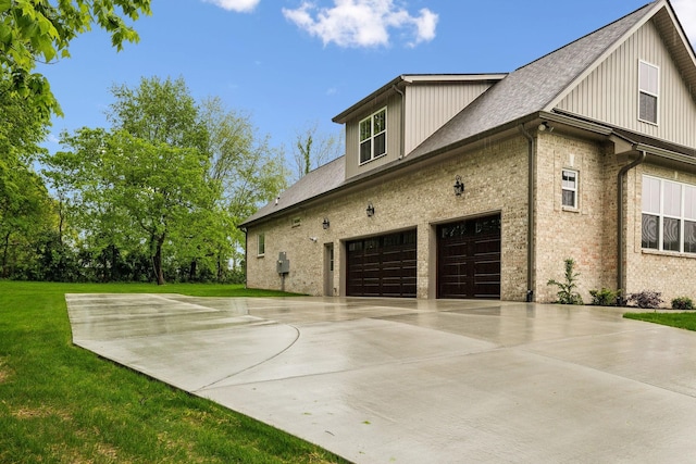8020 Traditions Ln, Columbia, TN 38401 - view of property exterior featuring concrete driveway, roof with shingles, a lawn, brick siding, and a garage