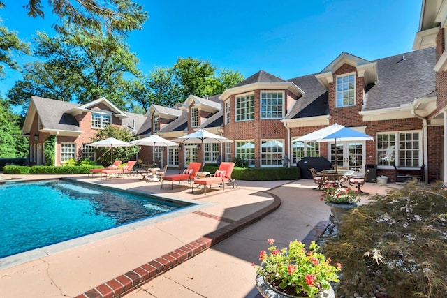 outdoor pool with french doors and a patio area