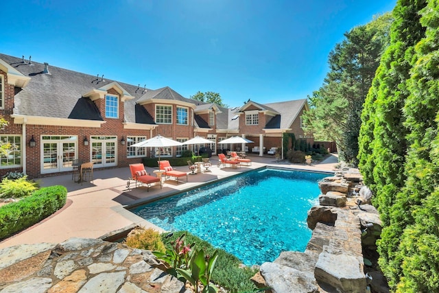 view of swimming pool with a patio, french doors, and a fenced in pool