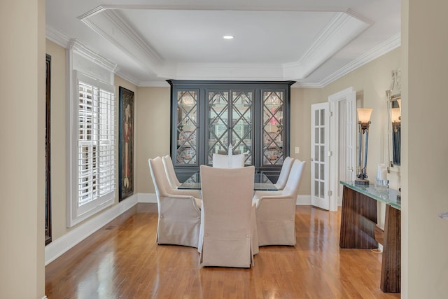 dining area with wood finished floors, crown molding, and baseboards