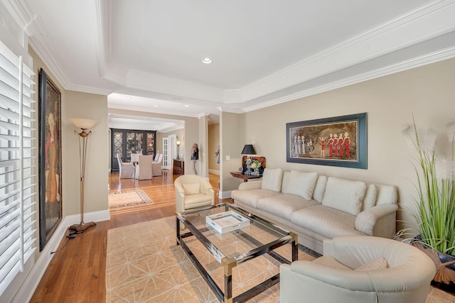living area featuring crown molding, a raised ceiling, baseboards, recessed lighting, and wood finished floors