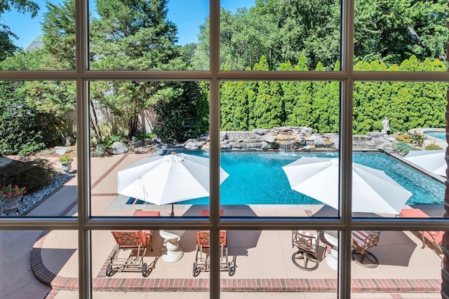 outdoor pool with fence and a patio area