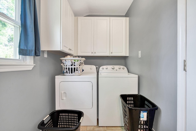 clothes washing area featuring washing machine and clothes dryer and cabinet space