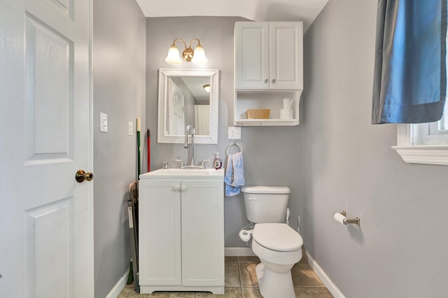 bathroom with toilet, tile patterned flooring, vanity, and baseboards