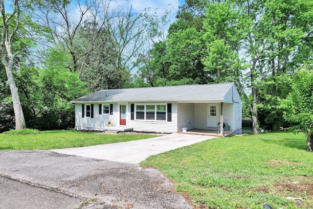 single story home with driveway, a carport, and a front yard