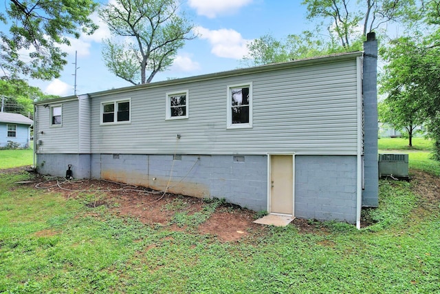 rear view of property with a chimney, a lawn, and crawl space