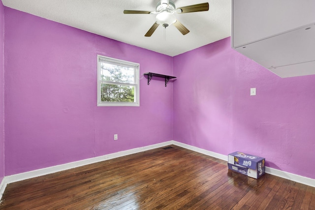 spare room featuring baseboards, visible vents, hardwood / wood-style flooring, and a ceiling fan
