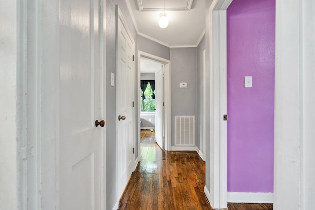 hallway featuring crown molding, visible vents, baseboards, and dark wood-type flooring