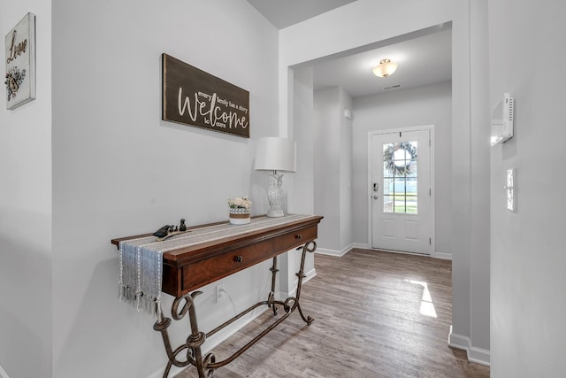 entryway with baseboards and wood finished floors