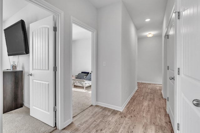 hall featuring recessed lighting, baseboards, and light wood-type flooring