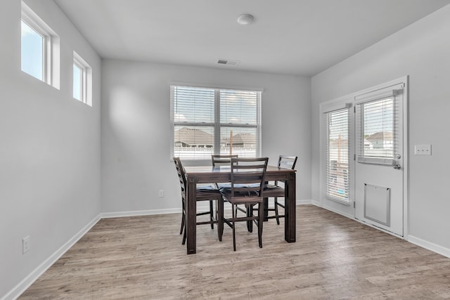 dining area featuring baseboards, light wood-type flooring, and visible vents