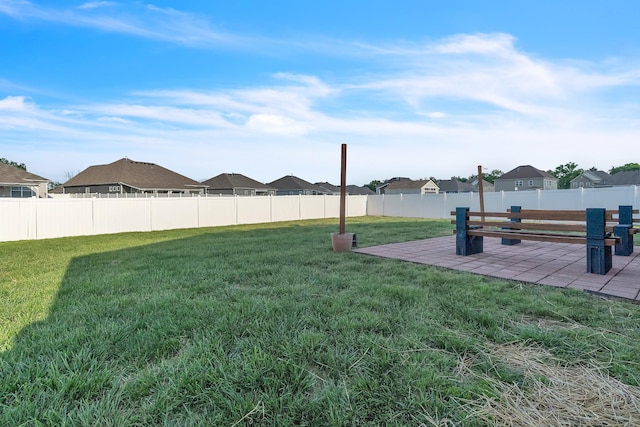 view of yard featuring a residential view, a fenced backyard, and a patio area
