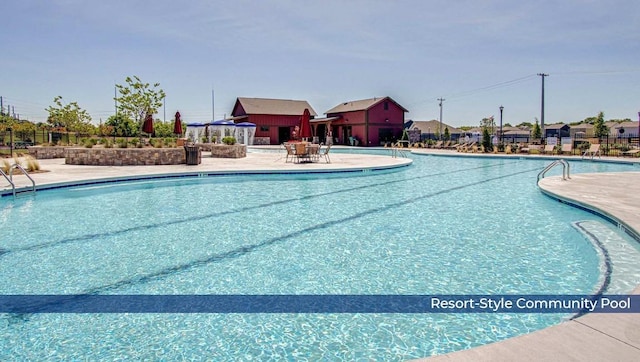 community pool with fence and a patio area