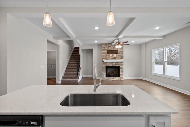 465 Herman Dr, Clarksville, TN 37042 - kitchen with a sink, ceiling fan, a stone fireplace, dishwashing machine, and wood finished floors