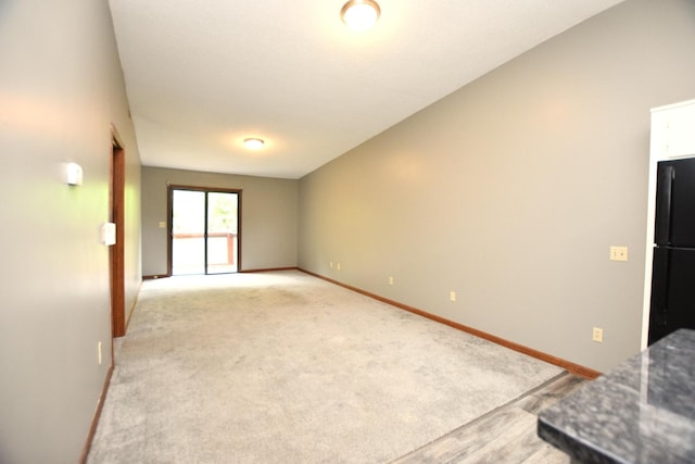 unfurnished living room with light colored carpet and baseboards