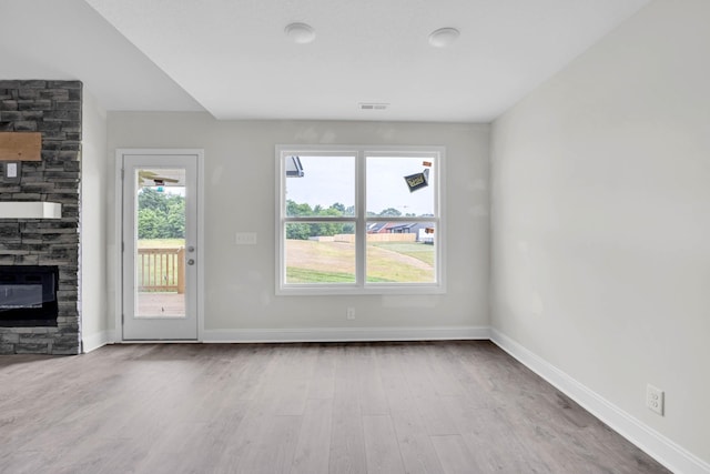 497 Herman Dr, Clarksville, TN 37042 - unfurnished living room featuring a stone fireplace, wood finished floors, and baseboards