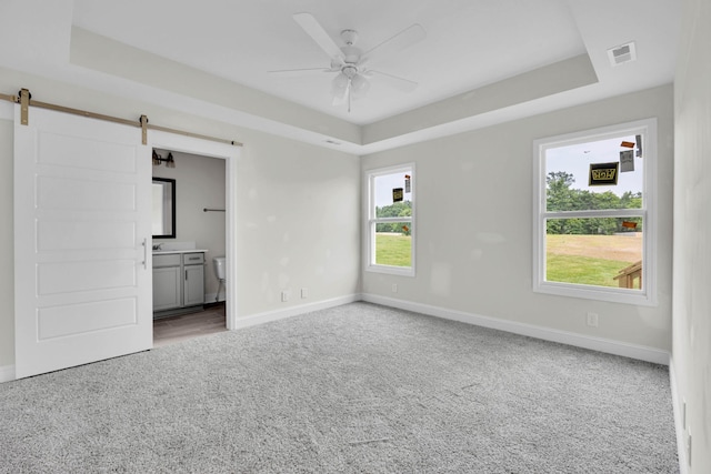 497 Herman Dr, Clarksville, TN 37042 - unfurnished room featuring a tray ceiling, carpet floors, a barn door, baseboards, and ceiling fan