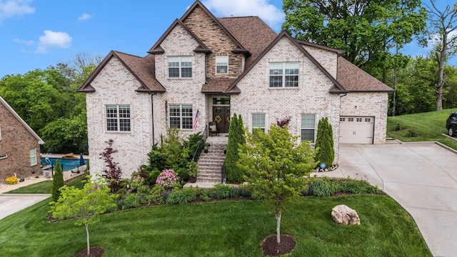 view of front of property featuring driveway, a front lawn, and brick siding