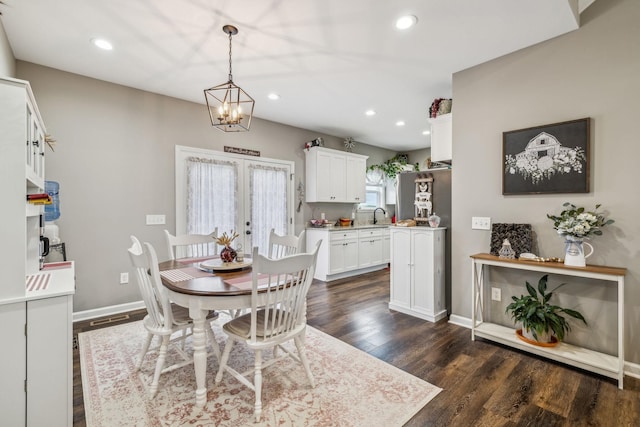 dining space featuring dark wood-style floors, baseboards, recessed lighting, french doors, and a notable chandelier