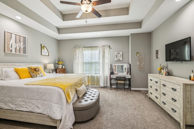bedroom featuring light colored carpet, recessed lighting, a tray ceiling, and baseboards