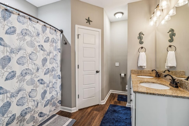 bathroom featuring a sink, wood finished floors, and baseboards