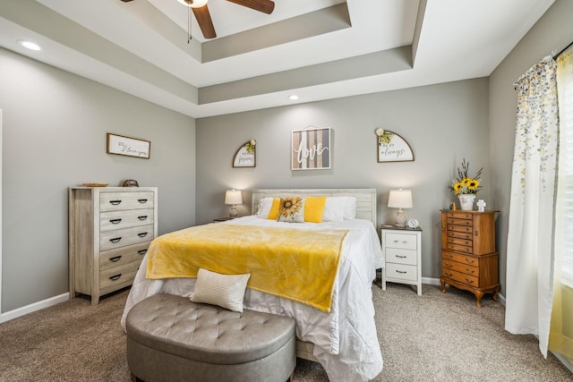 bedroom with baseboards, recessed lighting, light colored carpet, and a tray ceiling