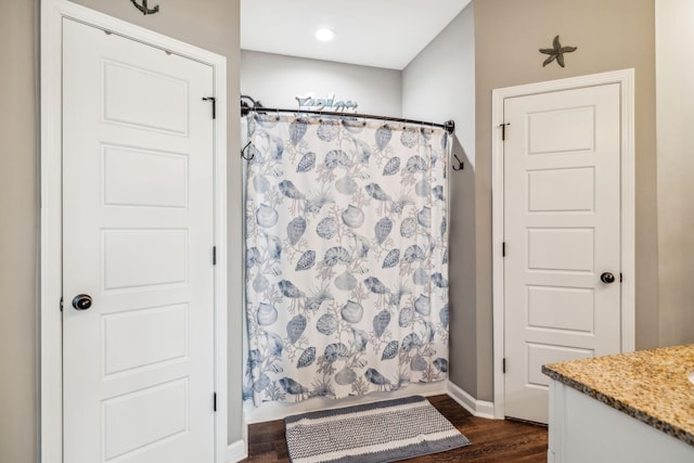 full bath with wood finished floors, vanity, a shower with shower curtain, and baseboards