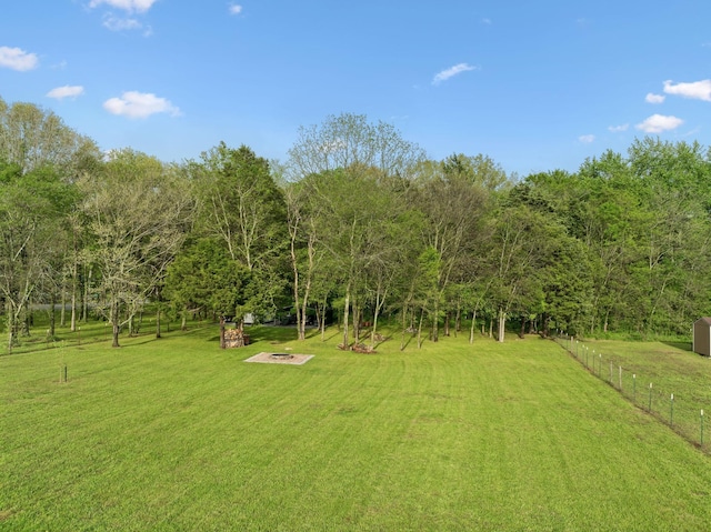view of yard with a fire pit and fence