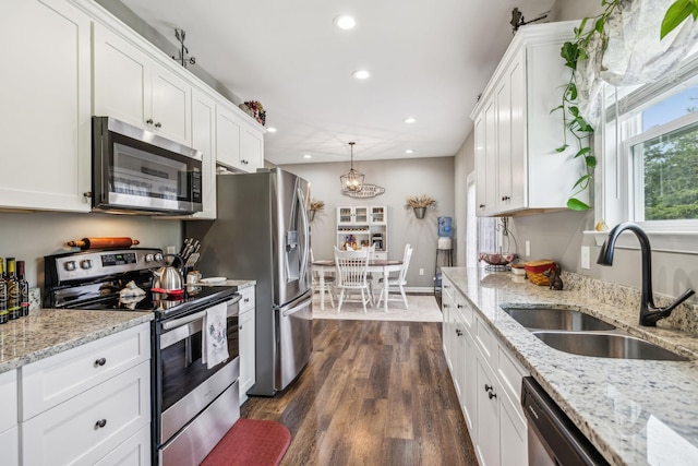 kitchen with appliances with stainless steel finishes, white cabinetry, recessed lighting, and a sink