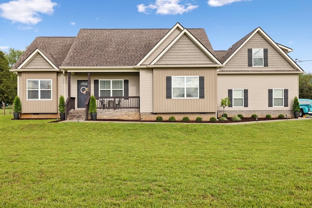 craftsman-style home featuring covered porch, a shingled roof, and a front yard