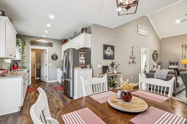 dining space featuring baseboards, an inviting chandelier, recessed lighting, vaulted ceiling, and dark wood-type flooring