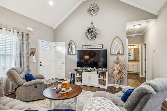 living area with attic access, wood finished floors, high vaulted ceiling, and baseboards
