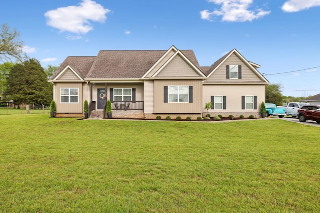 craftsman house with a porch, a front yard, board and batten siding, and roof with shingles