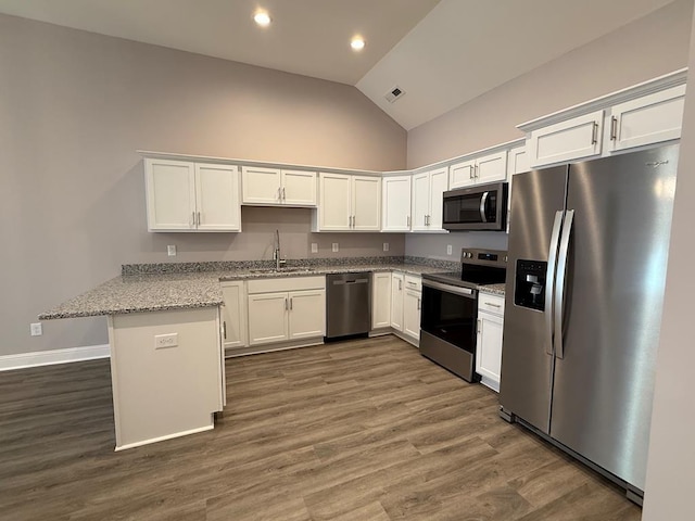 kitchen featuring a sink, a peninsula, stainless steel appliances, and white cabinetry