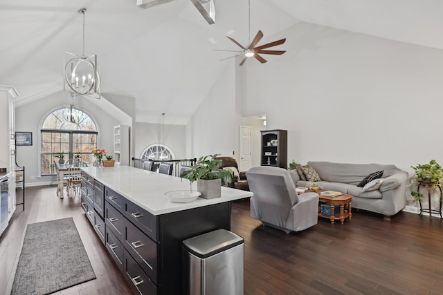 kitchen featuring high vaulted ceiling, decorative light fixtures, light countertops, open floor plan, and ceiling fan with notable chandelier