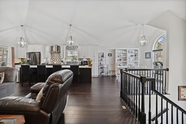 living room featuring a wealth of natural light, an inviting chandelier, and lofted ceiling