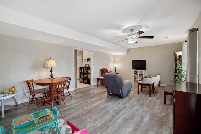 living room with baseboards, wood finished floors, and a ceiling fan