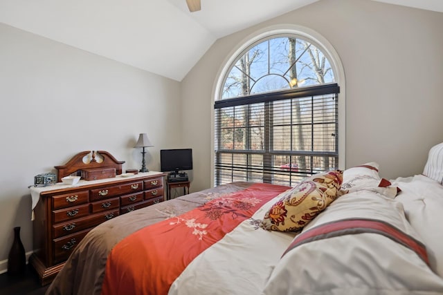 bedroom with a ceiling fan, wood finished floors, lofted ceiling, and baseboards
