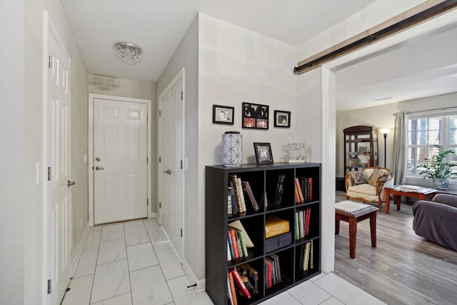 hall featuring marble finish floor and baseboards