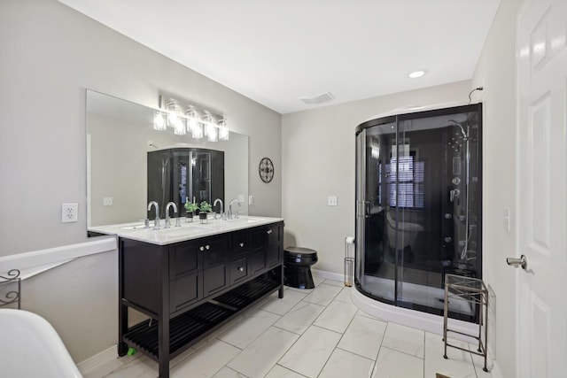 bathroom with double vanity, marble finish floor, toilet, a sink, and a stall shower