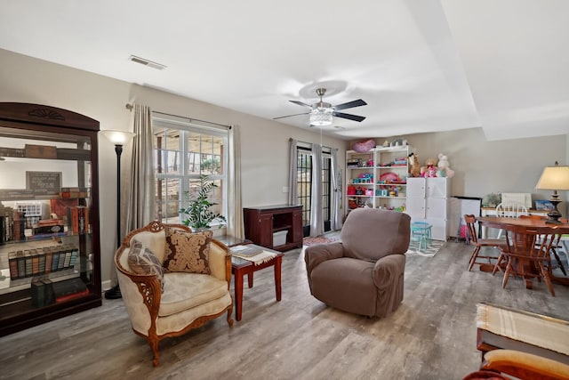 sitting room featuring visible vents, wood finished floors, and ceiling fan