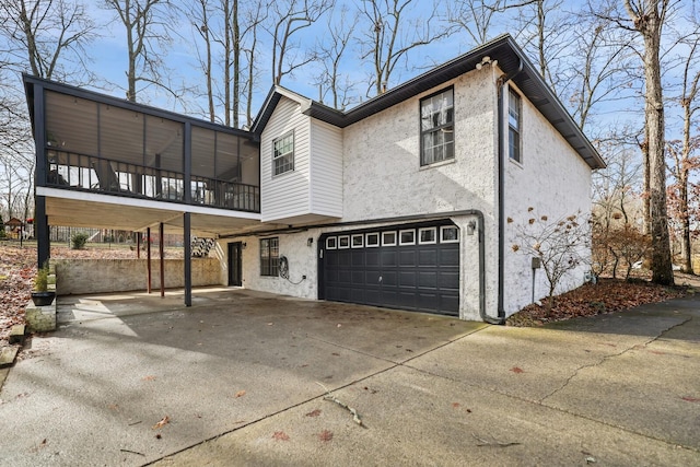 back of house with stucco siding, concrete driveway, and a garage